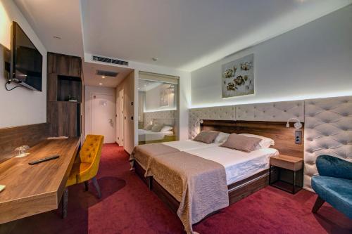 a bedroom with a bed and a desk and a couch at Hotel Scala d'Oro in Vodice