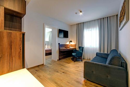 a living room with a couch and a desk at Hotel Scala d'Oro in Vodice