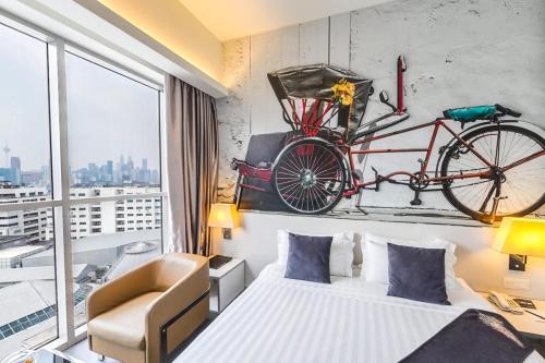 a bedroom with a bed and a bike on the wall at Vivatel Kuala Lumpur in Kuala Lumpur