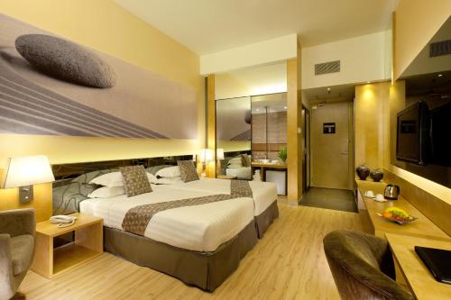 una camera d'albergo con letto e TV di Vivatel Kuala Lumpur a Kuala Lumpur