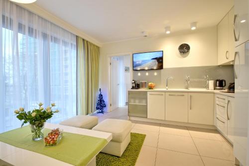 a kitchen and living room with a couch and a table at Horyzont-jantar314 in Międzyzdroje