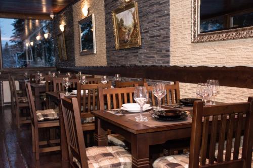 a restaurant with wooden tables and chairs with wine glasses at Platinvm B&B in Predeal
