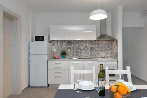 a kitchen with a table and a white refrigerator at ArtApArt Z in Rabac