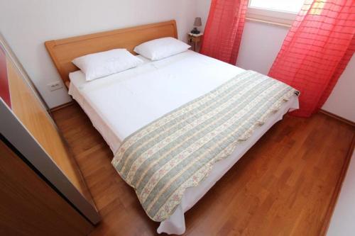 Schlafzimmer mit einem weißen Bett und roten Vorhängen in der Unterkunft Apartment Alen in Rovinj