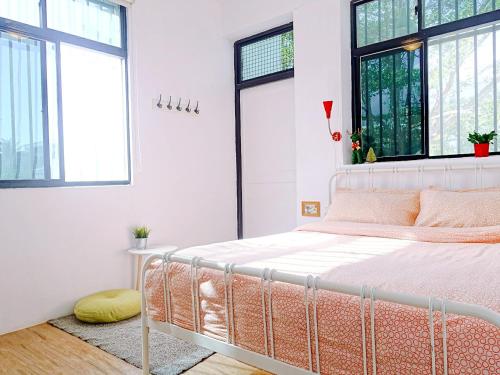 1 dormitorio con 1 cama en una habitación con ventanas en 都蘭朋友家 Dulan Friends Hostel en Donghe