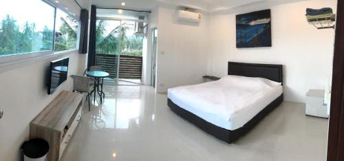 1 dormitorio con cama, mesa y ventana en Sleep inn Samui, en Choeng Mon Beach