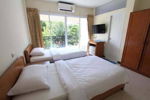 a bedroom with two beds and a large window at Subhamitra Hotel Hua Hin-SHA Certified in Hua Hin