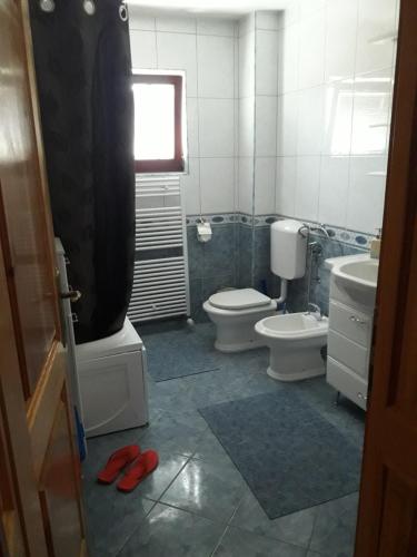 a bathroom with two toilets and a sink and a window at Sweet Holiday Home in Hadžići