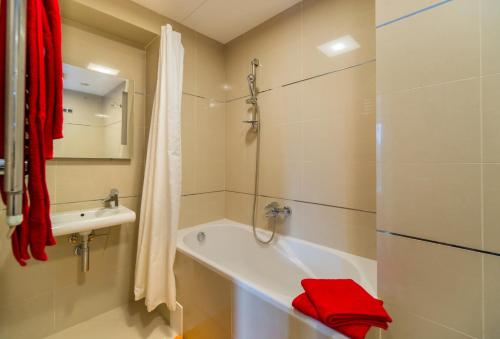 a bathroom with a tub and a shower and a red towel at Timber view apartment Silver Mountain Poiana Brasov in Poiana Brasov