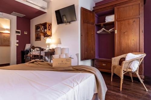 a bedroom with purple walls and a bed and a chair at Hotel Pocho in San Vito lo Capo