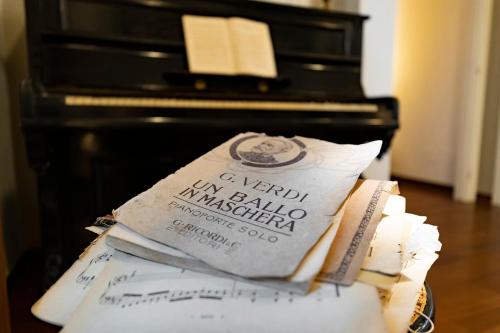 a stack of books in front of a piano at Hotel Pocho in San Vito lo Capo