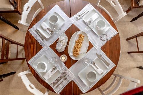 a round table with white dishes and a plate of food at Hotel Pocho in San Vito lo Capo