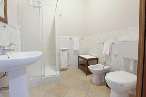 a white bathroom with a toilet and a sink at Cannatello home - Affittacamere in Villaggio Mosè