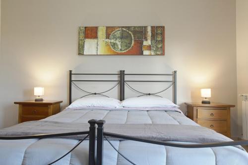 Cannatello home - Affittacamere في فيلاجيو موس: غرفة نوم مع سرير مع مواقف ليلتين ومصباحين