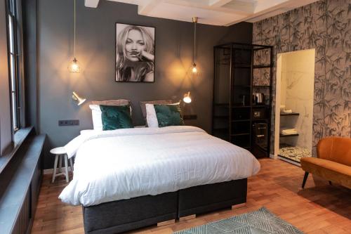 een slaapkamer met een groot wit bed en een stoel bij The Blossom House Amsterdam in Amsterdam