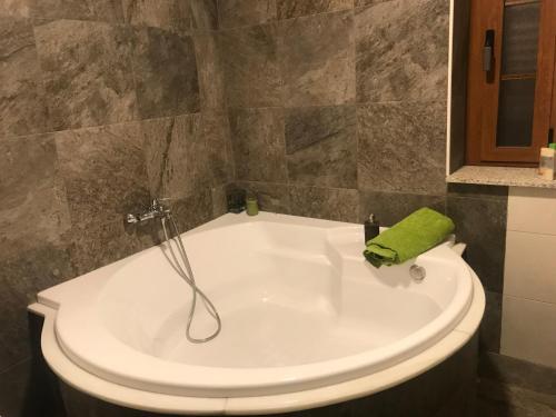 y baño con bañera y toalla verde. en Finca La Vega en Zamora