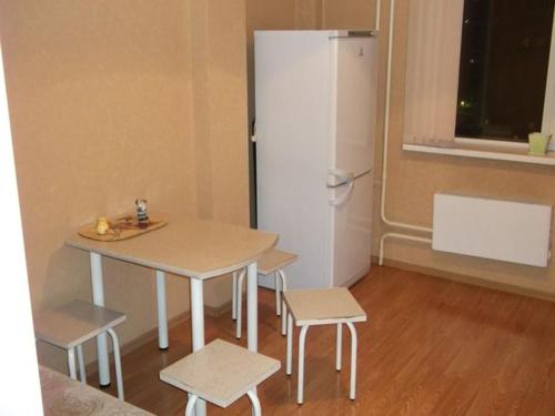 ノヴォシビルスクにある1к Семьи Шамшиных 24のキッチン(テーブル、白い冷蔵庫付)