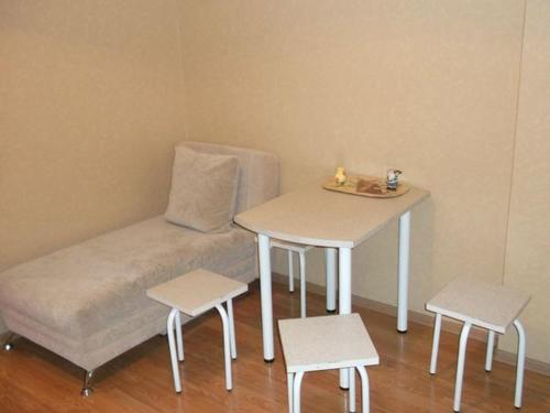 ノヴォシビルスクにある1к Семьи Шамшиных 24の小さなベッド1台(テーブル、スツール2脚付)