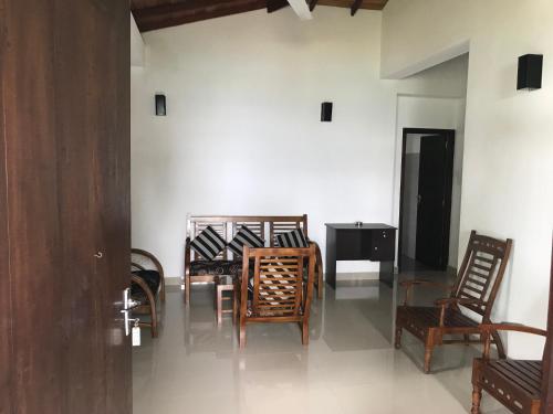 a group of chairs and a table in a room at Unawatuna Beach Bungalow - in Unawatuna