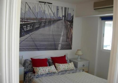 a bedroom with a picture of a pier on the wall at Cala Regina in San Juan de Alicante