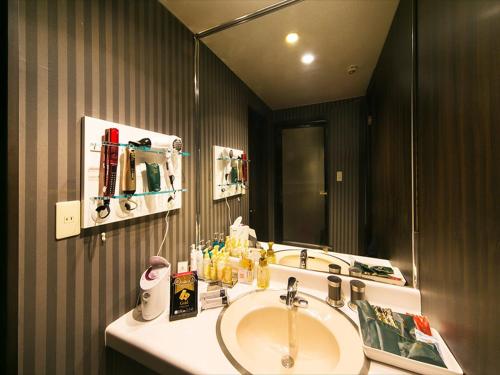 a bathroom with a sink and a mirror at Hotel Renaissance Sendai -Adult Only in Sendai