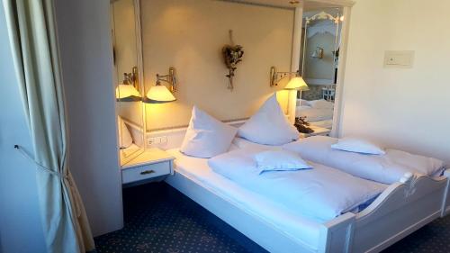 a bedroom with two beds and a mirror at Hotel Almhof Rupp in Riezlern