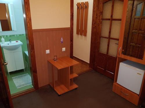 a bathroom with a sink and a wooden table at Pension Bittner in Braşov