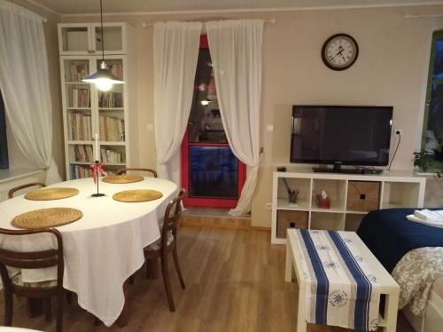 a living room with a table and chairs and a tv at Apartmány Ruprechtov in Hroznětín