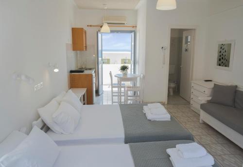 a bedroom with a bed and a couch and a kitchen at Zacharakis Studios in Kamari
