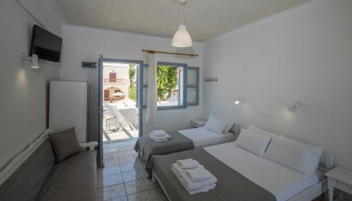 a bedroom with a bed and a couch and a tv at Zacharakis Studios in Kamari