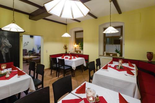 a restaurant with white tables and chairs with red napkins at Hotel & Ferienwohnungen Bohlenblick in Saalfeld