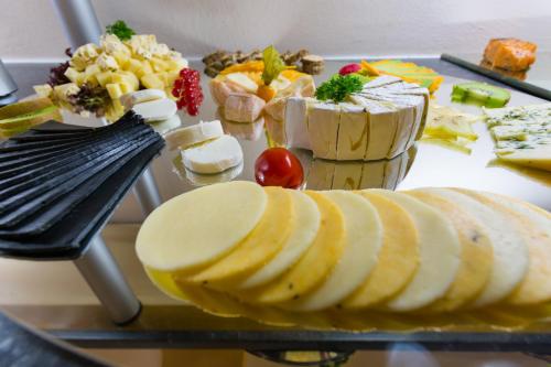 a tray of cheese and fruit on a table at Hotel & Ferienwohnungen Bohlenblick in Saalfeld