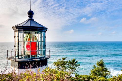 a lighthouse on the beach with the ocean behind it at La Petite Maison in Oceanside