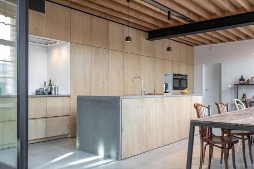a kitchen with wooden walls and a table with chairs at b room in Bruges