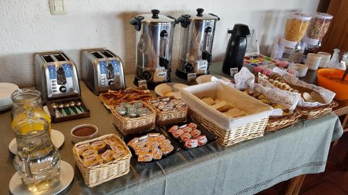 a table with baskets of pastries and other items on it at La Posta Hotel y refugio De Montana in Mina Clavero