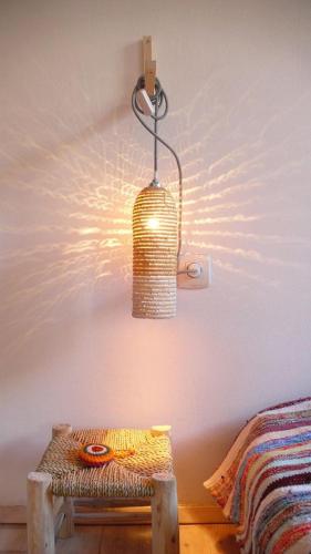 a light hanging from a wall next to a bed at Art Riad Au Bord De La Mer in El Jadida