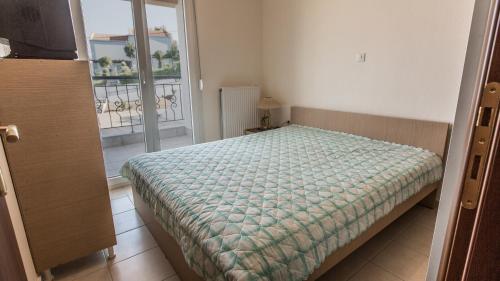 a bedroom with a bed and a view of a balcony at Mezoneta Elani in Siviri