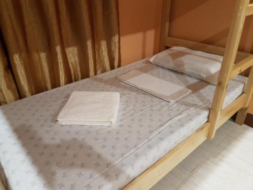 a bunk bed with a mattress and a towel on it at Stella'z guesthouse in Siquijor