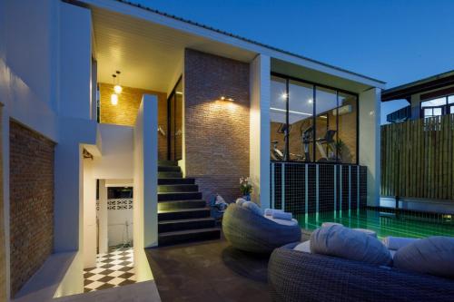 a house with a swimming pool in front of it at Chala Number 2 Art and Gallery in Chiang Mai