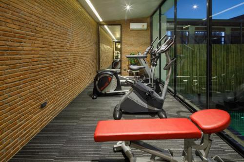 a gym with cardio equipment in a brick wall at Chala Number 2 Art and Gallery in Chiang Mai