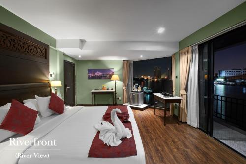 a hotel room with a bed with swans on it at Baan Wanglang Riverside, Bangkok in Bangkok