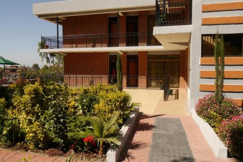a building with a balcony and flowers in front of it at Tabor Hotel Lalibela in Lalībela