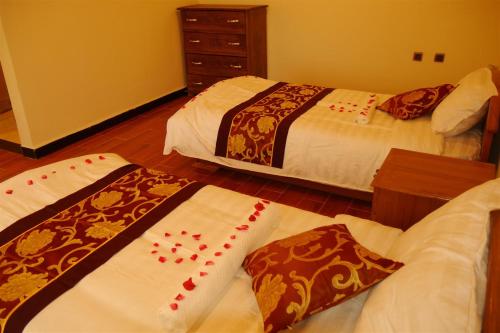 two beds in a hotel room with red chineseabandabandabandabandabandaband at Tabor Hotel Lalibela in Lalībela