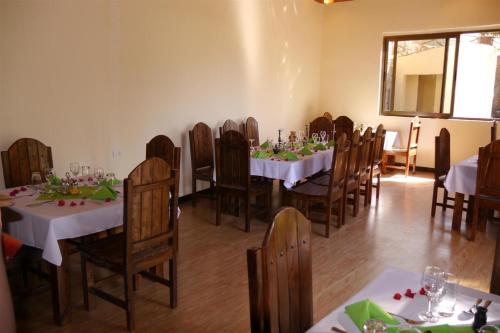 a dining room with white tables and wooden chairs at Tabor Hotel Lalibela in Lalībela