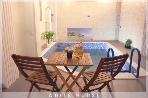 - une table et des chaises en face de la piscine dans l'établissement White House, à Tbilissi