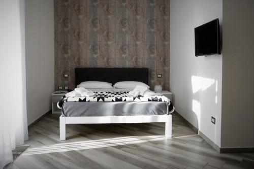 1 dormitorio con 1 cama y TV en la pared en Hermes rooms for tourists, en Nápoles