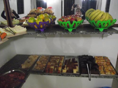 a buffet of different types of food on a shelf at Pousada JK in Foz do Iguaçu