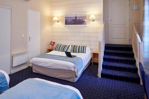 a hotel room with two beds and a staircase at Hôtel du Nord in Annecy