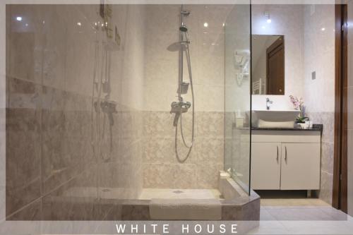 ein Badezimmer mit Dusche und ein weißes Haus in der Unterkunft White House in Tbilisi City