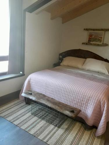 a bedroom with a bed with a wooden head board at La Cabaña de Catalina in Sotres